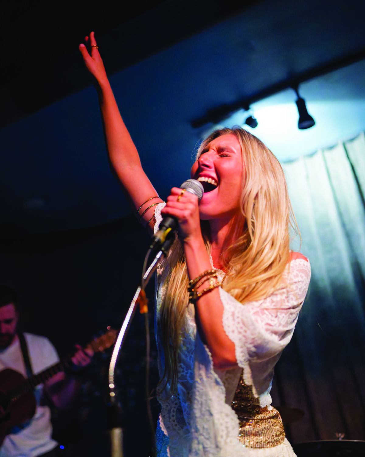 Sylvie singing with one arm raised